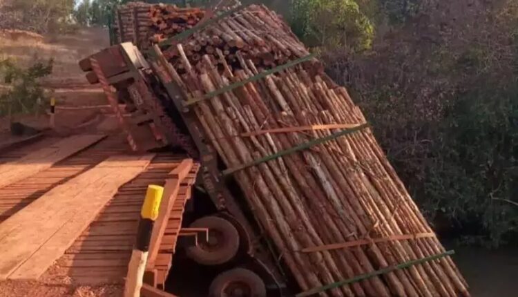 Carreta tenta atravessar ponte de madeira e cai em rio